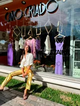 Pantalón dorado de corte acampanado con aberturas laterales en el ruedo.