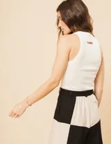 Short de lino color beige y naranja, de tiro alto con elástico en la pretina trasera, cierre delantero y botón, bolsillos delanteros y dobladillo invisible.