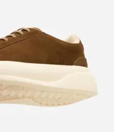 Championes de cuero nobuk en color marrón, con cordones elásticos y suela alta de goma en tono marfil.