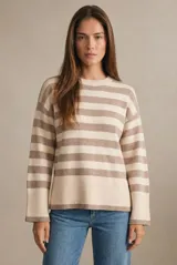 Sweater de punto con diseño a rayas horizontales en color negro y crema. Presenta cuello redondo, mangas largas con puños acanalados y un detalle de borde en tono bronce metalizado en el ruedo y los puños.
