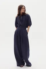 Pantalón sastrero de lino color azul marino, de corte wide leg, tiro alto con pinzas en la parte delantera y bolsillos laterales.
