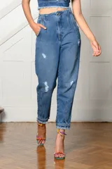 Pantalón de jean celeste con roturas, tiro alto, corte holgado y tobillos ajustados.