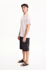 Bermuda de jean de algodón de estilo skater oversize en color negro, con diseño clásico de bolsillos y trabillas para cinto.