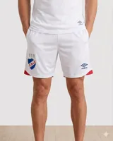 Short de fútbol Umbro del Club Nacional de Football, modelo Home 2025. Diseño en color blanco con detalles en rojo en los laterales y el escudo del club junto al logo de la marca en las piernas.