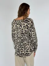 Blusa beige con estampado animal print de leopardo, escote en V y mangas largas.