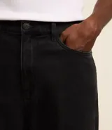 Pantalón baggy jeans color negro, con cierre de botón y cremallera, y bolsillos. Confeccionado en tejido de jean 100% algodón.