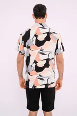 Camisa de manga corta con cuello clásico y estampado abstracto en tonos blanco, negro, gris y naranja.