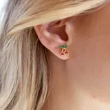 Par de aros dorados con forma de cerezas, con cristales verdes y magenta.