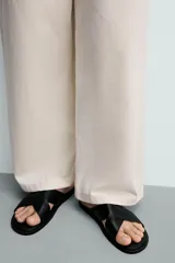 Sandalia plana de diseño minimalista con dos tiras anchas cruzadas en el empeine y suela a tono.