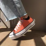 Championes Converse Chuck Taylor All Star Lift color naranja con plataforma blanca y cordones blancos.