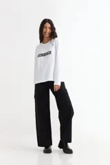 Remera de manga larga color beige con cuello redondo a la base. Presenta un estampado frontal con un dibujo de labios en color fucsia y la palabra 'BESITO' en color negro.