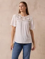 Blusa color crema de crepe con detalle de crochet en el escote, mangas cortas amplias.