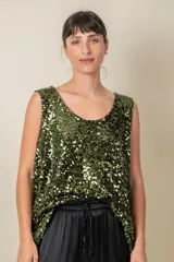 Blusa sin mangas confeccionada en tela cubierta de lentejuelas doradas y plateadas, con escote redondo y corte holgado.