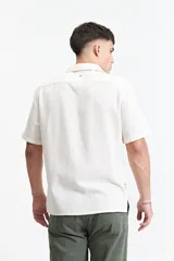 Camisa de manga corta color crema con textura, cuello clásico y calce regular.