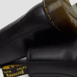 Botas de cuero negro con cordones, diseño clásico de 8 ojales, suela de goma con cámara de aire y costuras amarillas características de la marca.