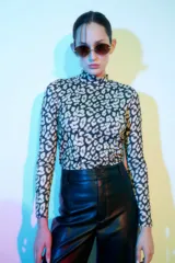 Top de lycra con cuello alto y mangas largas, estampado animal print en tonos blanco y negro.