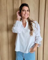 Blusa de algodón con cuello mao y volados, mangas largas con puños elásticos y corte holgado.