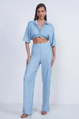 Camisa celeste de tejido con textura, corte cropped, cuello camisero y mangas cortas.