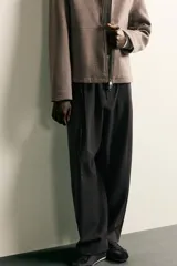Pantalón de corte balloon fit confeccionado en tejido con viscosa. Presenta cintura ajustable con cinturón integrado, pliegues frontales, bolsillos laterales y bolsillos traseros de doble vivo. Cierre frontal con cremallera y botón.