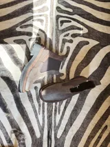 Bota Chelsea de cuero color marrón chocolate con elástico lateral negro y suela track color negro.