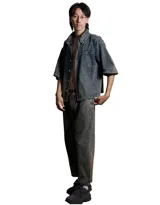 Pantalón unisex de denim azul con lavado artesanal en tonos beige. Corte holgado, cintura elástica, pierna ancha y largo estándar.