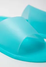 Sandalia chata color negro de goma semi transparente con tira ancha sobre el empeine.