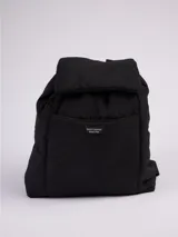 Mochila negra de tela acolchada con cierre superior tipo flap y bolsillo frontal con etiqueta con logo de la marca Rusty.