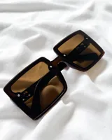Lentes de sol con montura cuadrada de acetato color marrón y cristales marrones.