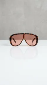 Lentes de sol con armazón oversized carey y cristales marrones en tono degradé, con diseño envolvente.
