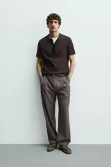 Camiseta de manga corta con cuello panadero y cierre frontal de tres botones. Presenta una textura acanalada y un corte regular fit.