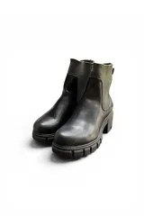 Bota corta de cuero sintético negro con inserciones elásticas laterales acanaladas y suela chunky con taco cuadrado.