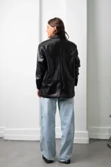 Blazer de eco cuero negro con hombreras, solapas clásicas y cierre frontal con botones.