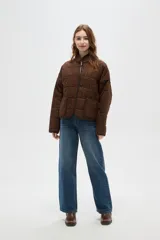 Campera acolchada de algodón con estampado animal print de leopardo en tonos marrones. Presenta cuello alto, cierre frontal, mangas largas y dos bolsillos frontales con ribetes oscuros.