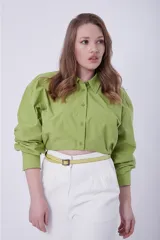 Camisa verde de mangas largas abullonadas, con cuello clásico y cierre frontal con botones.