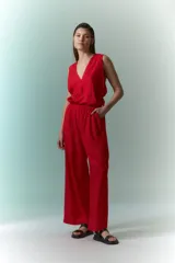 Mono rojo con cuello halter, corte holgado y pierna ancha.