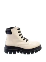 Borcego de cuero color blanco hueso, estilo militar o de combate, con cordones negros y suela track gruesa de goma negra. Presenta cuello acolchado negro.