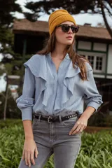 Camisa celeste de manga larga con cuello mao y volados frontales.