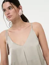 Top de tirantes finos con escote en V, confeccionado en tela satinada con caída fluida.