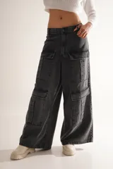 Pantalón jean cargo wide leg color gris oscuro, de tiro medio/bajo con pierna y bota ancha. Tiene cuatro bolsillos grandes en las piernas y largo a los tobillos.