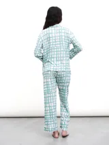 Conjunto de pijama de dos piezas, color verde menta con estampado de cuadros irregulares en blanco. Incluye camisa de manga larga con botones y pantalón largo con cintura elástica.