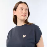 Camiseta de punto gris oscuro sin mangas, con cuello redondo y un pequeño bordado en forma de corazón dorado en el pecho.