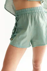 Short gris claro de lino, con cintura elastizada, cordones cruzados en los laterales y pespuntes en contraste.