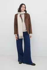 Blazer de gamuza color marrón, con solapas clásicas, cierre frontal de tres botones y bolsillos laterales con solapa.