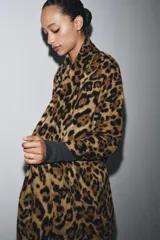 Pañuelo rectangular con estampado animal print de leopardo en tonos marrones y negros, con acabados deshilachados en los bordes.