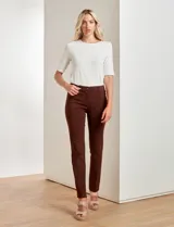 Pantalón de vestir marrón de corte recto, con pretina con pasadores, botón y cierre. Tiene tres bolsillos delanteros y dos bolsillos ojal en la parte trasera.