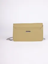 Bandolera rectangular color verde oliva, de símil cuero, con correa fija de cuero y cadena metálica. Tiene detalle de tachas plateadas en la solapa y broche a presión metálico.