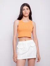 Minifalda blanca de algodón con cintura elastizada, cierre frontal con botón y dos bolsillos tipo cargo.