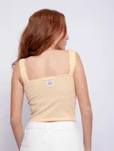 Top sin mangas con estampado de lunares, escote recto y tirantes anchos.