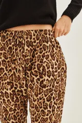 Pantalon de corte holgado con estampado animal print de leopardo, cintura elástica con cordón ajustable y bolsillos laterales.
