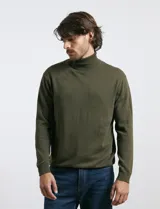 Polera de tejido de punto fino en color verde oliva, con cuello alto acanalado y mangas largas.